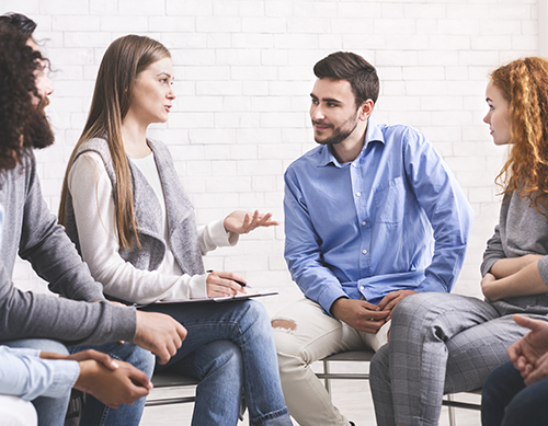 People sitting in circle and listening their mentor during group therapy session in rehab and they talk about contact positive pathways